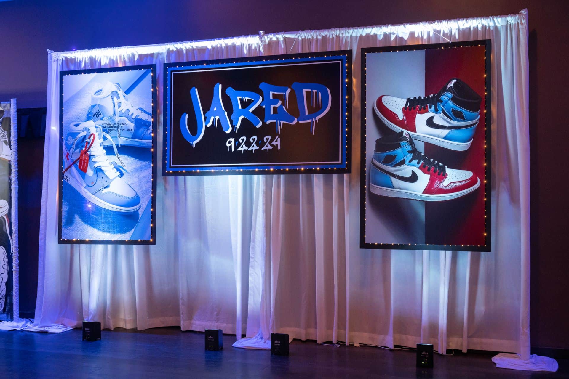 Custom Backdrop and Blow Up Sneakers on Pipe and Drape with LED Uplighting