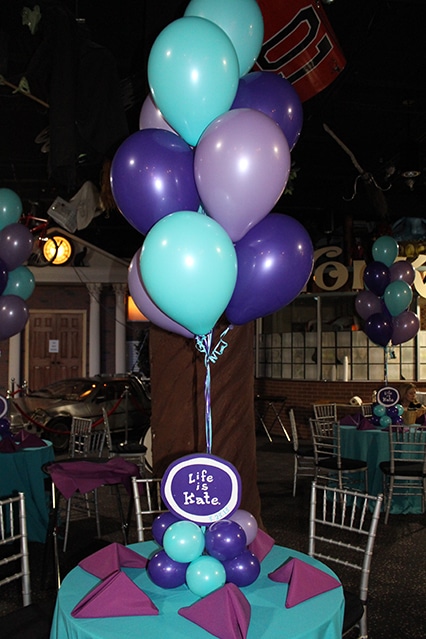 Purple and Turquoise Balloon Centerpieces with Cutout Logos in Balloon Bases