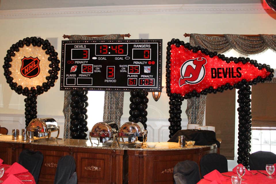 Hockey Themed Bar Mitzvah Scoreboard Backdrop with NJ Devils Pennant and Hockey Puck Balloon Sculptures