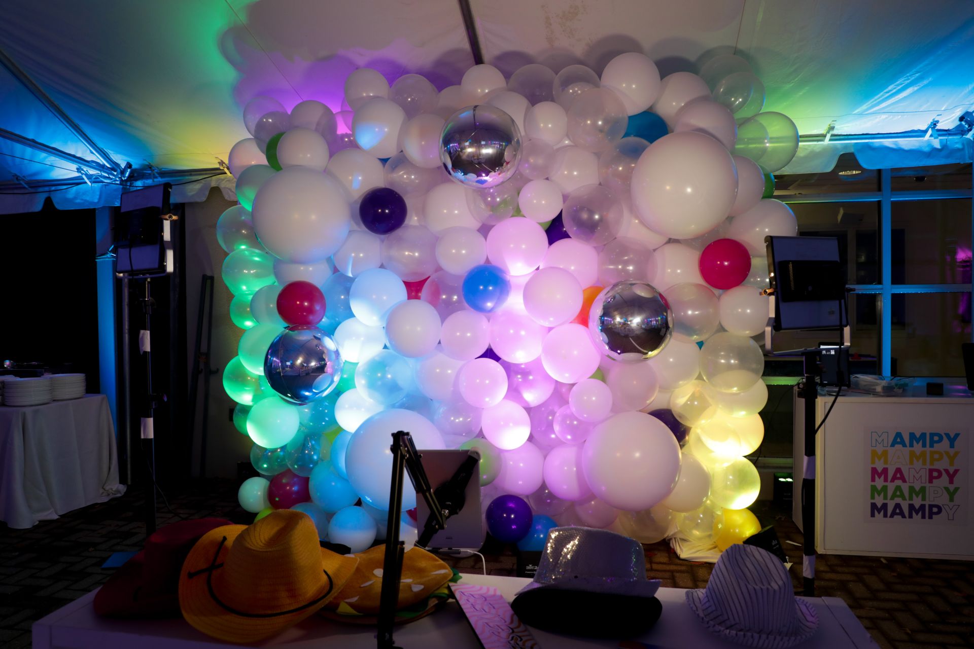 Beautiful White and Clear Balloon Wall with Blue, Green, Pink, Purple and Yellow Accents and Metallic Silver Orbz as Photo Op for Tent Party Decor