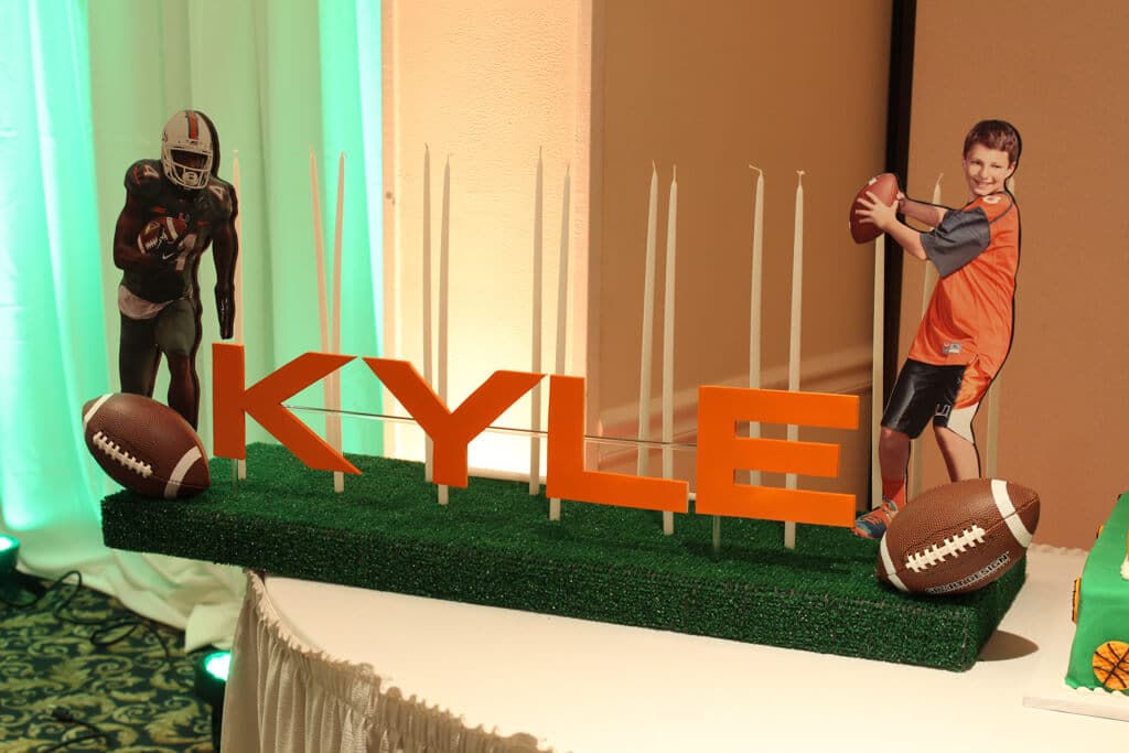 Football Themed Candle Lighting Display with Cutout Photos and Turf Base