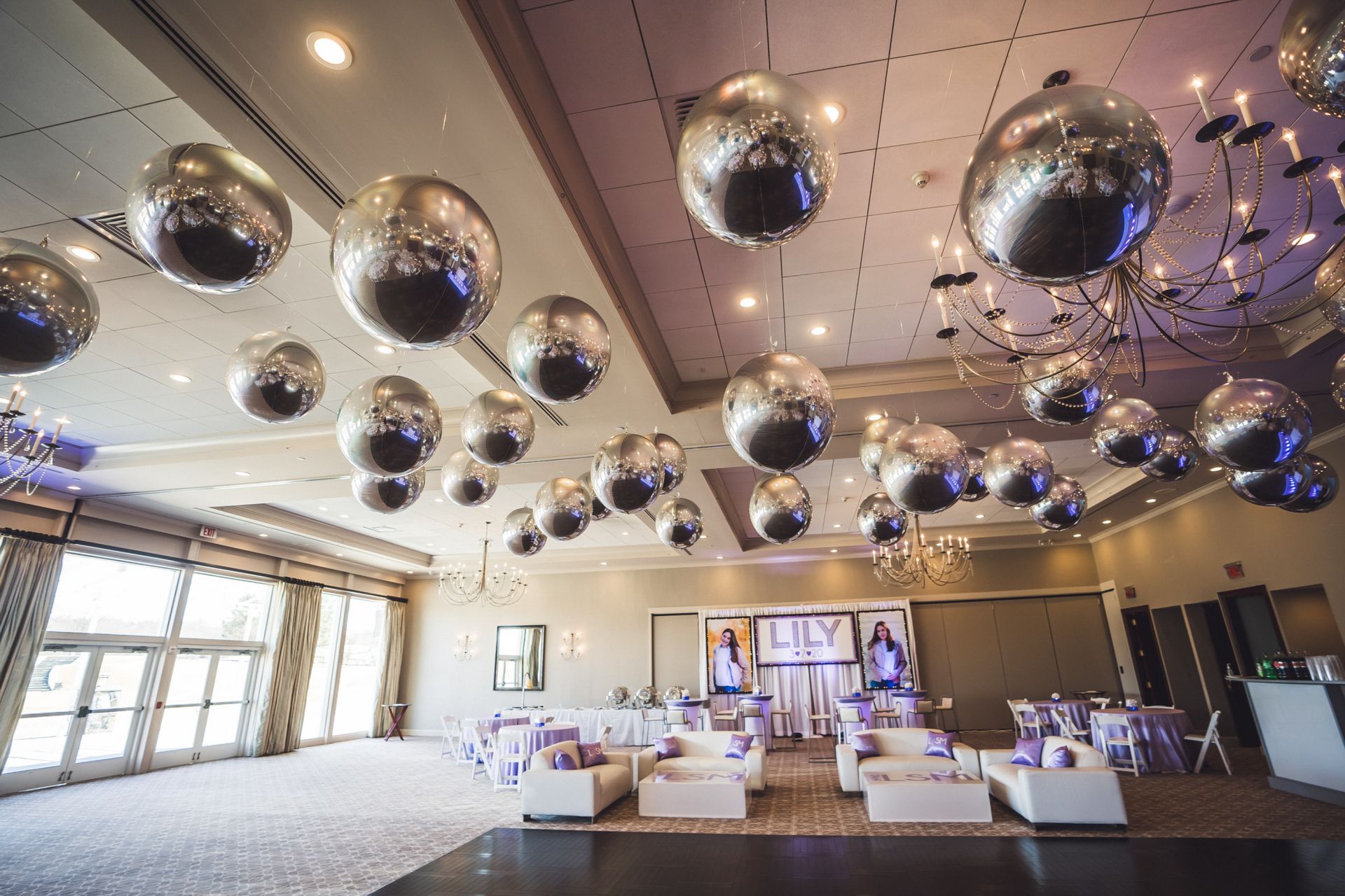 Beautiful Metallic Silver Orbz Ceiling Treatment for Bat Mitzvah Decor with Custom Backdrop and Blow Up Pictures, Custom Cube Cocktail Centerpiece and Custom Lounge Set Up with Pillows