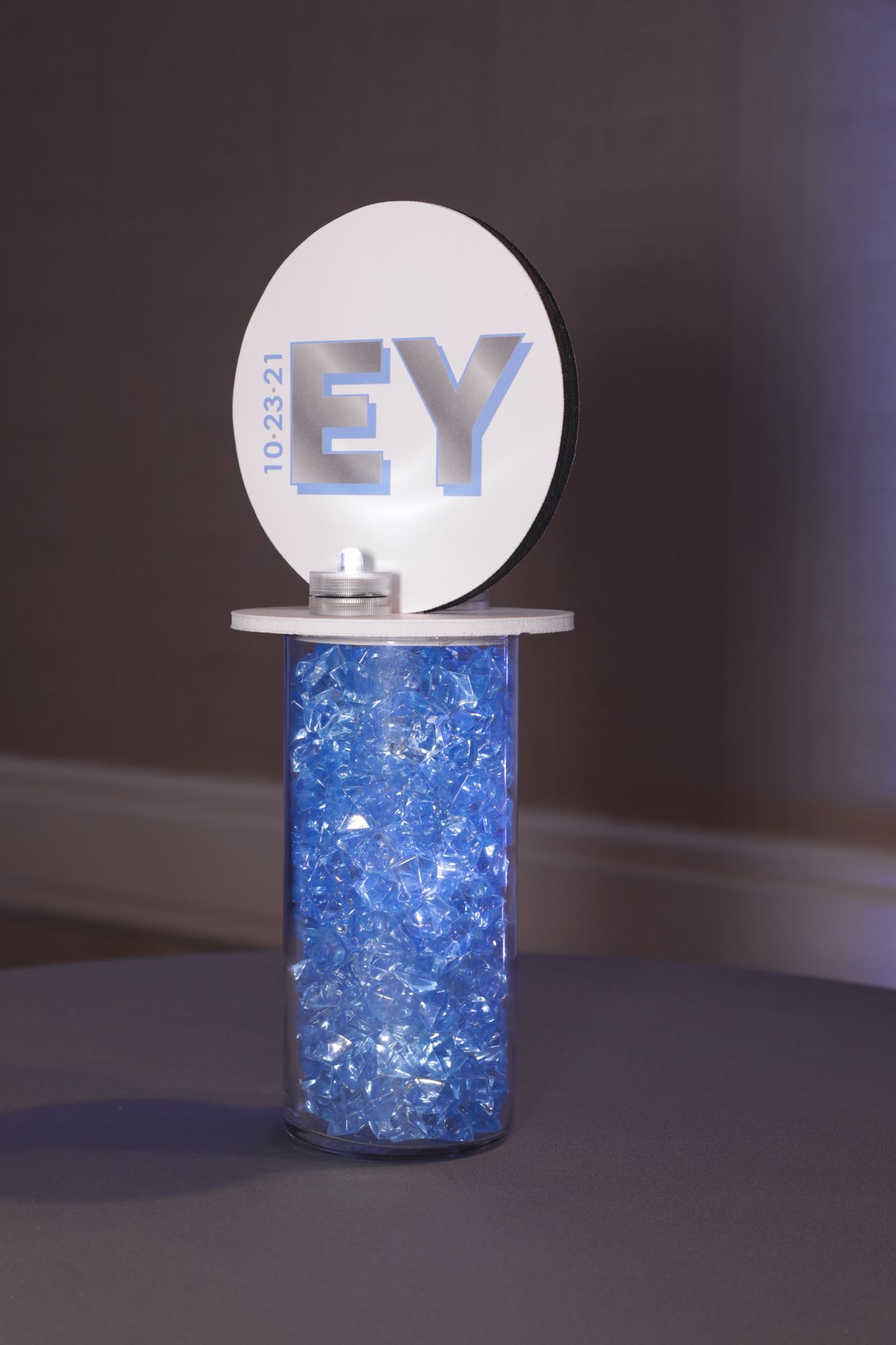 Beautiful LED Custom Logo Topper Centerpiece Over Pale Blue Chips for Bat Mitzvah Lounge Set Up