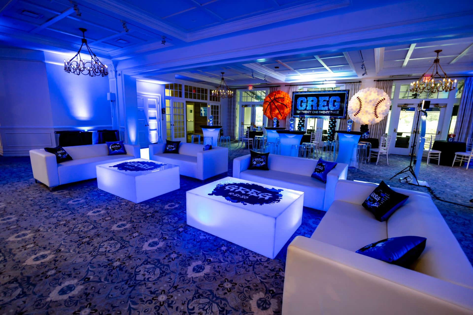 Sports Themed Bar Mitzvah Lounge with Custom Logo Tables, Logo Pillows and Custom Backdrop with Sports Ball Balloon Sculptures at Preakness Hills Country Club