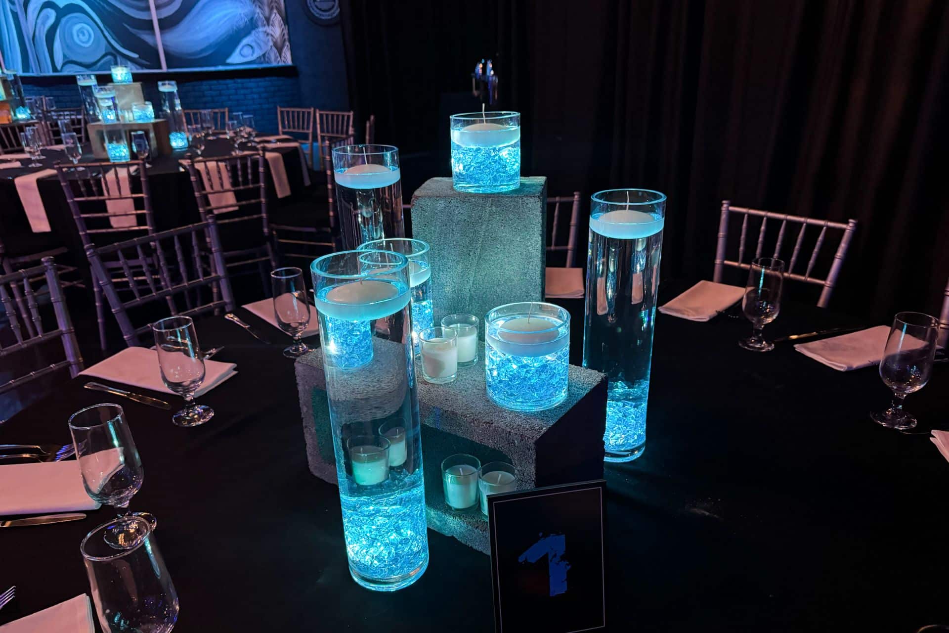 A Cinder Block Centerpiece Topped with Glass Cylinders Containing Blue LED Chips, Each Topped with a Floating Candle
