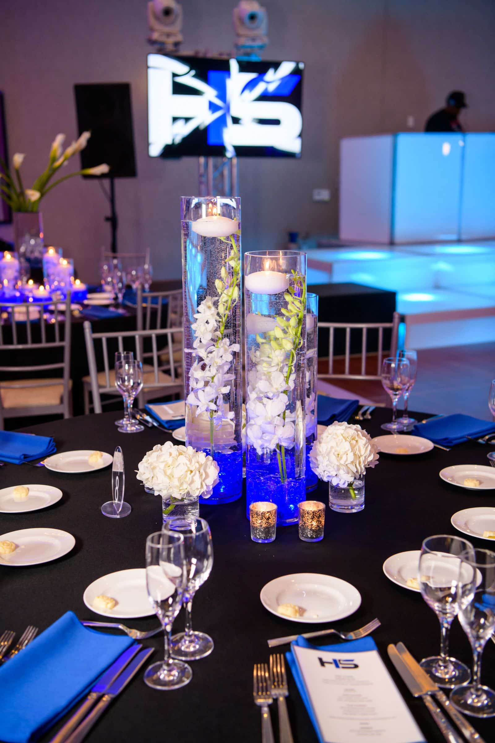 Orchid Centerpiece with LED Gems Topped with a Floating Candle alongside Hydrangeas