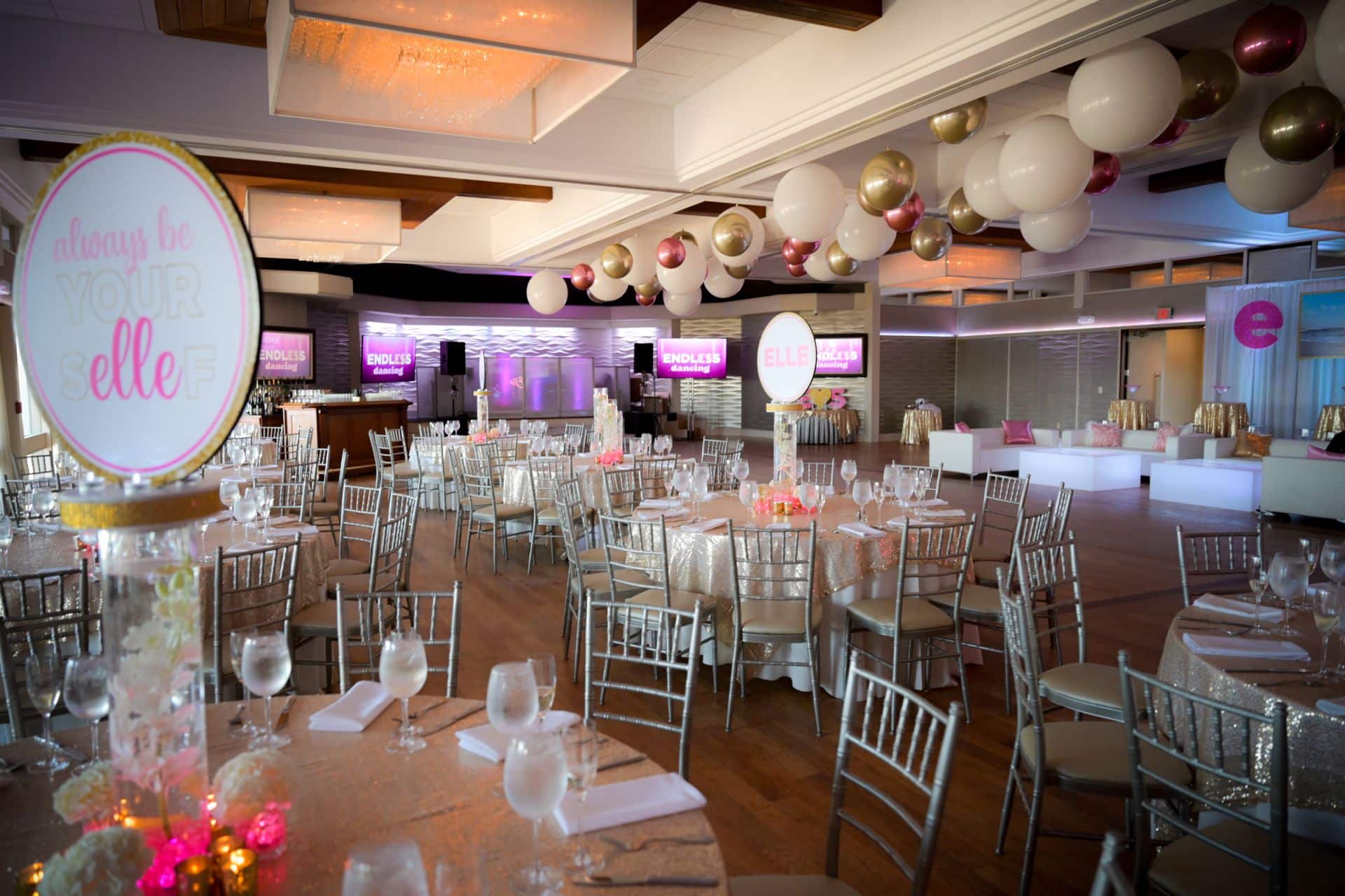 Orchid Centerpieces with Logo Toppers and a Balloon Ceiling with a Custom Lounge for a Bat Mitzvah at Crescent Beach Club