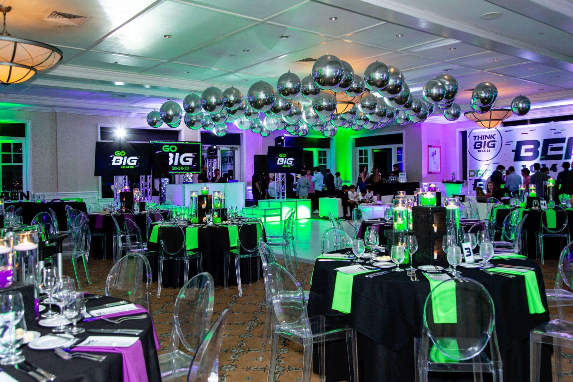 Neon Themed Bar Mitzvah with Silver Balloons over Dance Floor, LED Cinder Block Centerpieces, White Dance Floor and Custom Logo Sign Behind DJ at Tamarack Country Club