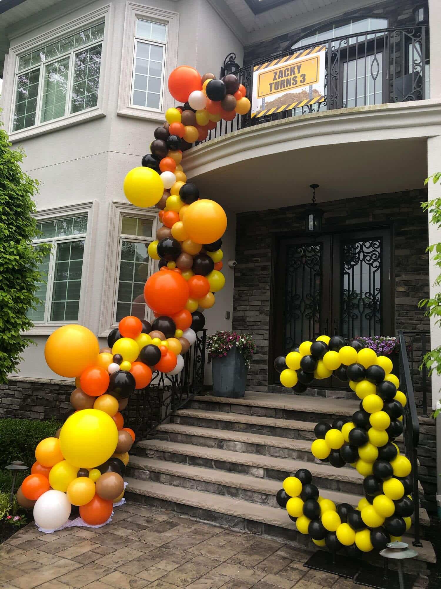 Construction Themed Organic Balloon Arch Over Entryway and Stairway for Outdoor Birthday Decor