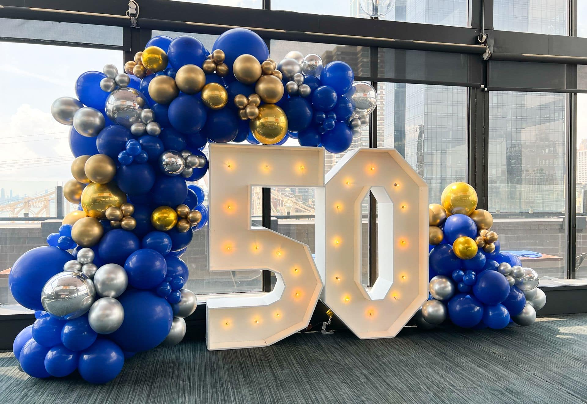 Blue, Silver and Gold Organic Balloon Garland over Marquee Numbers for 50th Birthday