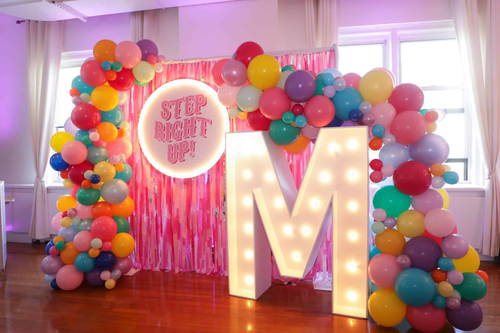 Carnival Themed Balloon Garland with Custom Tassel Backdrop and LED Marquee Letter for Bat Mitzvah Photo Booth