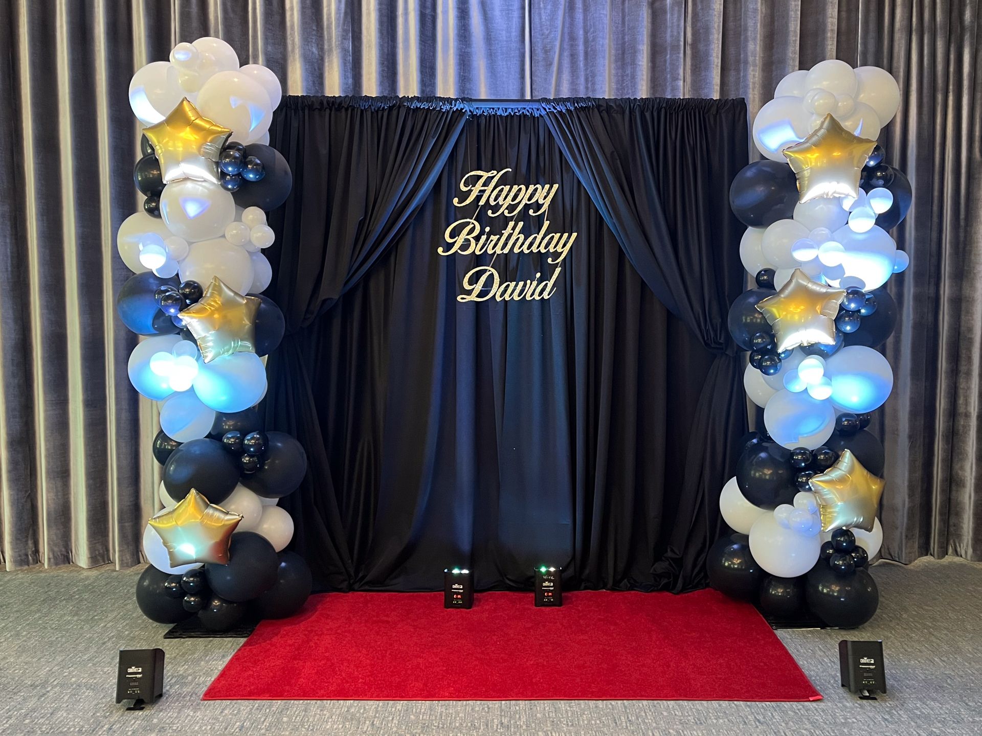 Balloon Columns Next To Black Draping With Glitter Sign In Front of a Red Carpet for a Birthday