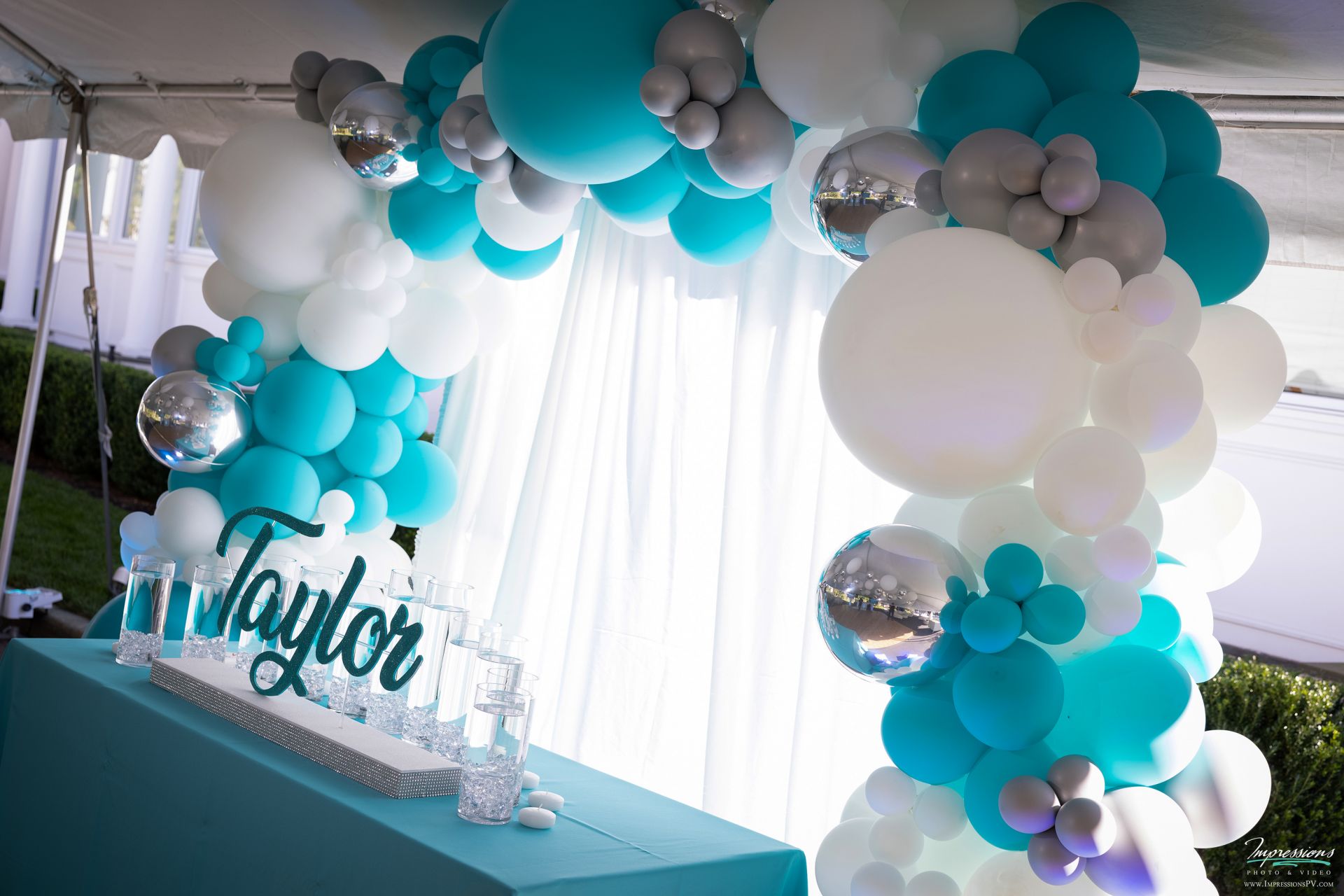 Turquoise and White Organic Balloon Arch with Pipe and Drape and LED Candle Lighting Display with Cylinders and Floating Candles for Outdoor Bat Mitzvah