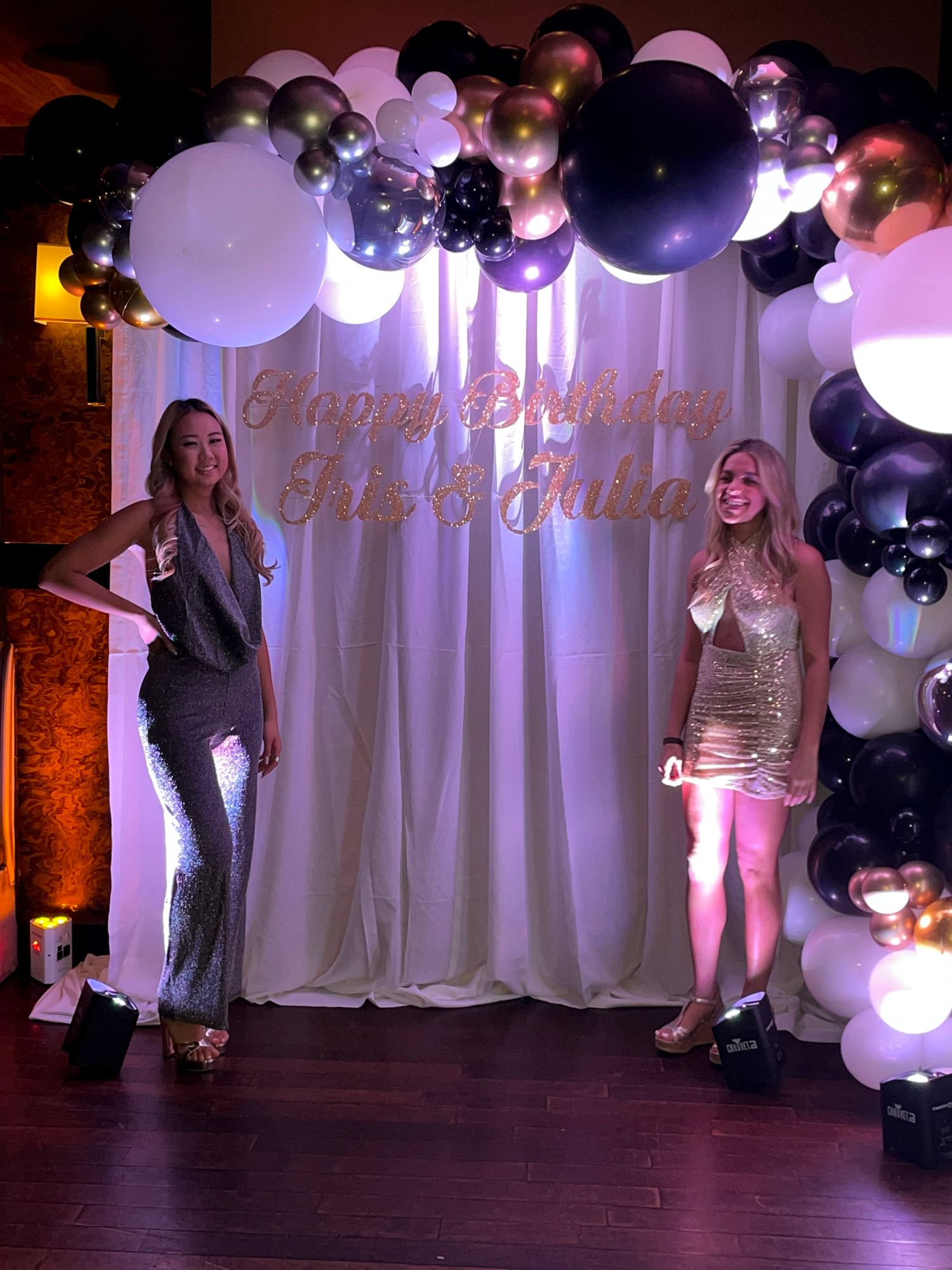 Birthday Girls with their Beautiful Black and White Organic Balloon Arch with Metallic Silver and Gold Accents Over Pipe and Drape Custom Hand Cut Signage