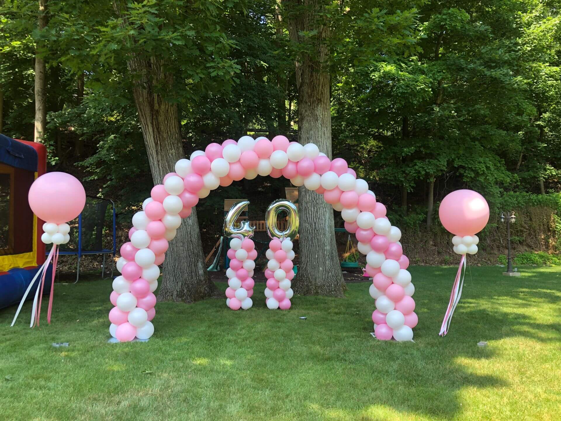 Pink and White Balloon Arch with Number Columns and Large Balloons with Tassels for Drive By Birthday