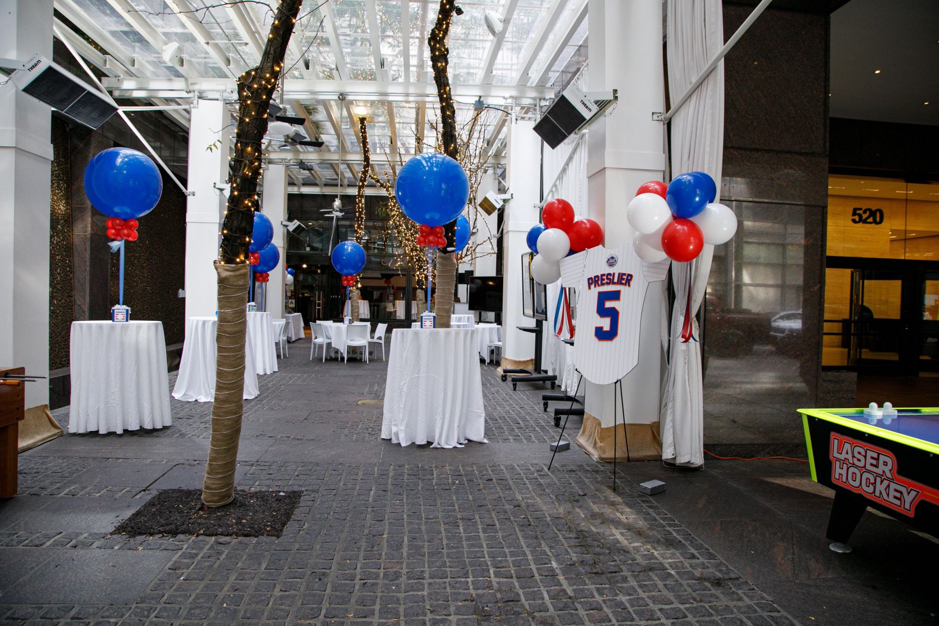 Beautiful Decor for Outdoor Party with Large Balloon Cocktail Centerpiece over Custom Logo Cube Base, Custom Cut Out Jersey Sign in Board and Balloon Clusters