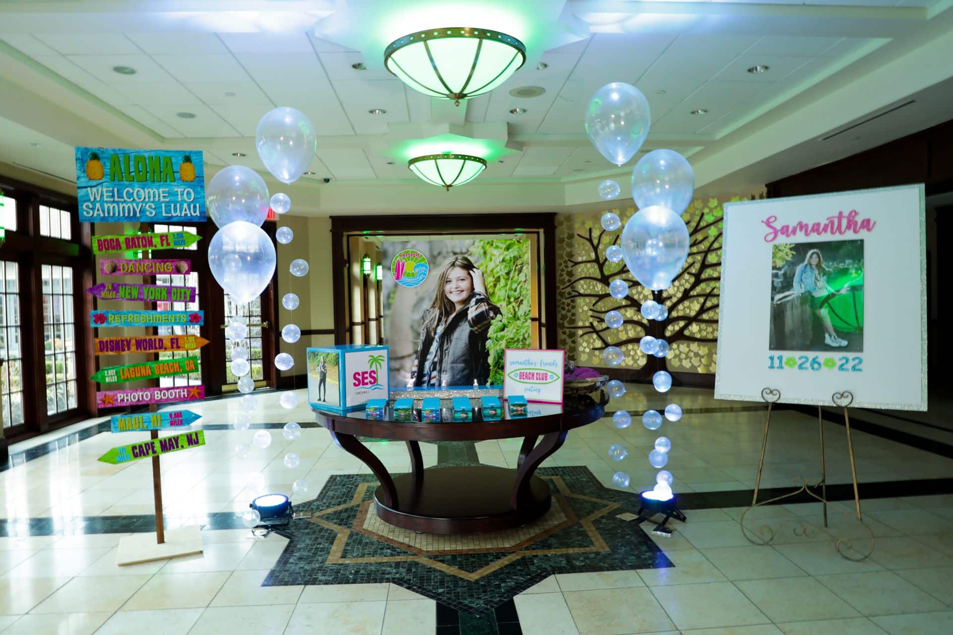 Beach Themed Entrance Decor with Blowup Photo Seating Card Display and Clear Bubble Balloons at Temple Emanu-el Closter