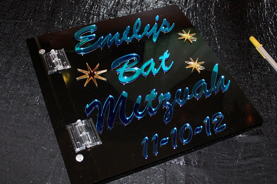 Black Lucite Sign in Book with Light Blue Mirror Lettering and Gold Stars