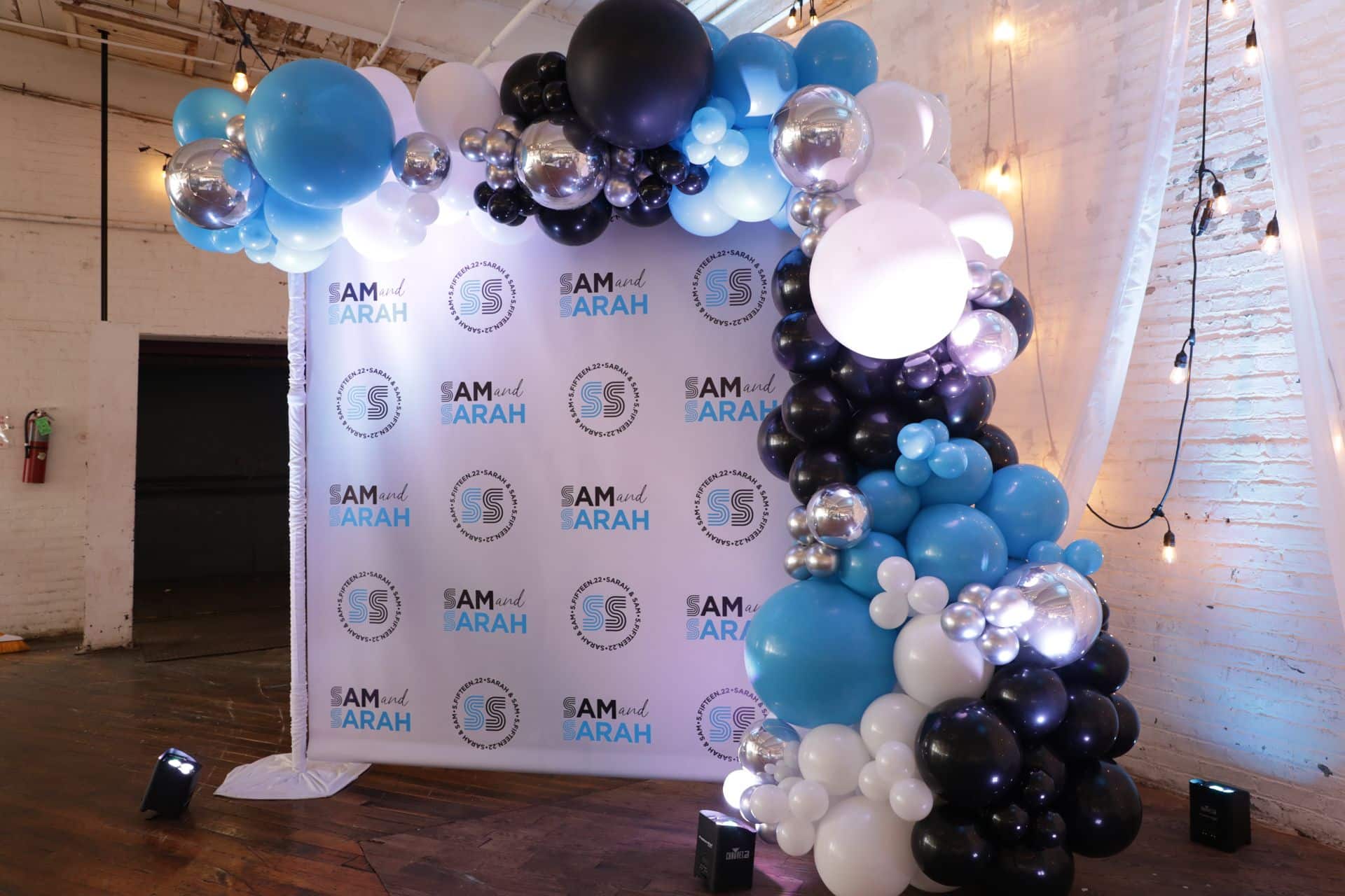 B'nei Mitzvah Step and Repeat with Blue, Black and White Organic Balloon Garland at Art Factory